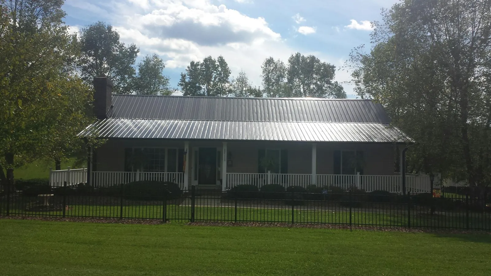 Gray metal roof on a brick ranch with a full width front porch — Gutter Guard Installation work by our crew in Royal Oak